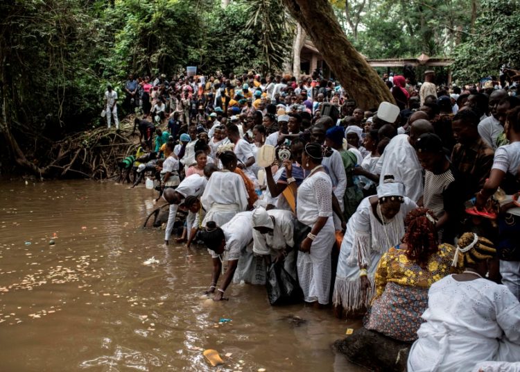 Devotees and participants offer sacrifices and prayers to the Osun river goddess and collect water from the sacred river during the Osun-Osugbo Festival in Osogbo, southwestern Nigeria, on August 17, 2018. - Thousands of people attend the yearly Osun-Osugbo Festival to celebrate and make sacrifices to the river goddess ?Osun? in return for fertility and good fortune. (Photo by Stefan HEUNIS / AFP)