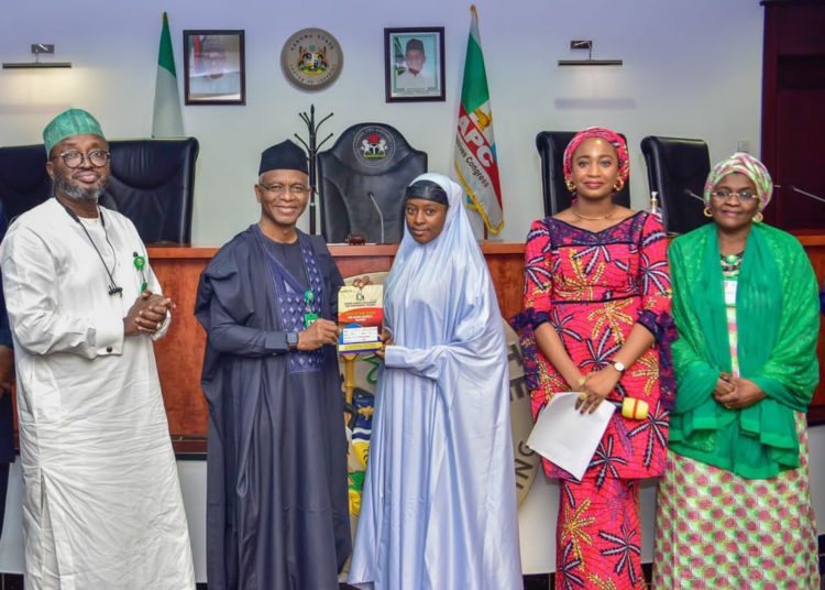 Governor Nasir El-Rufai handing over ownership documents to one of the traders who bought shops at Sheikh Abubakar Gumi market, along with Commissioner of Business, Innovation and Technology, Prof Kabir Mato (left), Hajiya Hafsat Mohammed Baba, Commissioner of Human Services and Social Development (right) as well as Managing Director of Kaduna Market Development and Management Company (KMDMC) Tamar Nandul at the ceremony.