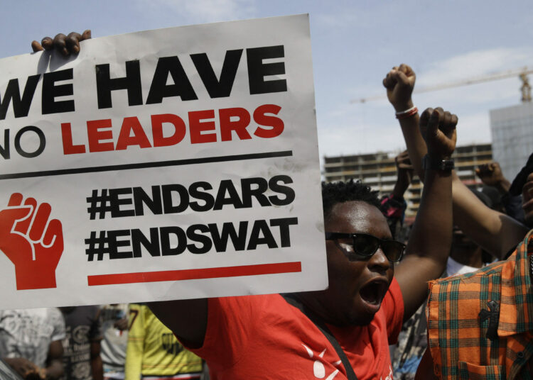 People hold banners as they demonstrate on the street to protest against police brutality in Lagos, Nigeria, Thursday Oct. 15, 2020. Protests against Nigeria's police continued to rock the country for the eighth straight day Thursday as demonstrators marched through the streets of major cities, blocking traffic and disrupting business. (AP Photo/Sunday Alamba)/XSA112/20289512829904//2010151700