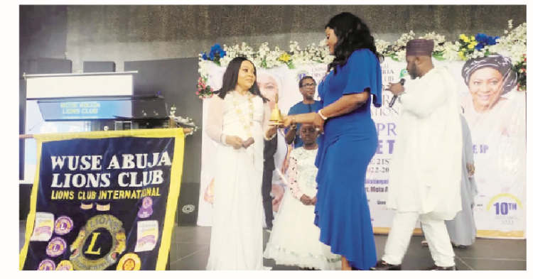 Wuse Abuja Lions Club Tamer, Lion Chika Frances Anuoro handing over the gown and gavel to the incoming president, Princess Doo Kene Tsumba NLCF,  JP to strike herself into office for the first time