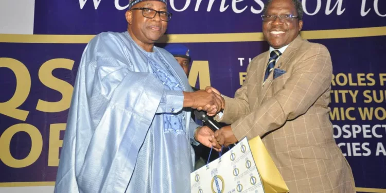 NIQS President, QS Olayemi M. Shonubi, FNIQS handing over a souvenir to the former Governor of Bauchi state, Mohammrd  Abubakar, SAN at the Job fair held organised by the Institute in Abuja.