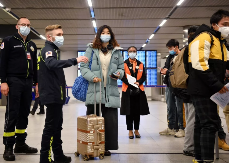 China Warns Of Countermeasures For Entry Restrictions 1 Passengers of a flight from China wait in a line for checking their COVID-19 vaccination documents as a preventive measure against the Covid-19 coronavirus, after arriving at the Paris-Charles-de-Gaulle airport in Roissy, outside Paris, on January 1, 2023. - France and Britain on December 30 joined a growing list of nations imposing Covid tests on travelers from China, after Beijing dropped foreign travel curbs despite surging cases -- and amid questions about its data reporting. (Photo by JULIEN DE ROSA / AFP)