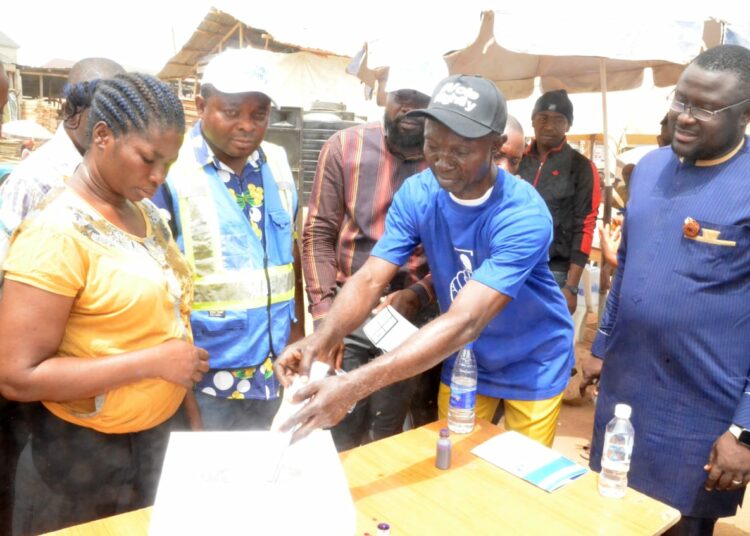 Chairman, Jabi Timber Market Association, Mr Sunday Okafor (2nd, R); casting his vote at the mock session during a 1-Day 2023 Election Sensitization Programme tagged: Voting Right and Say No To Election Violence, at Jabi Timber Market in Abuja on Wednesday (22/2/23). With him is the Convener/Executive Director, IKID Foundation, Dr Mer Best (R) and other participants.