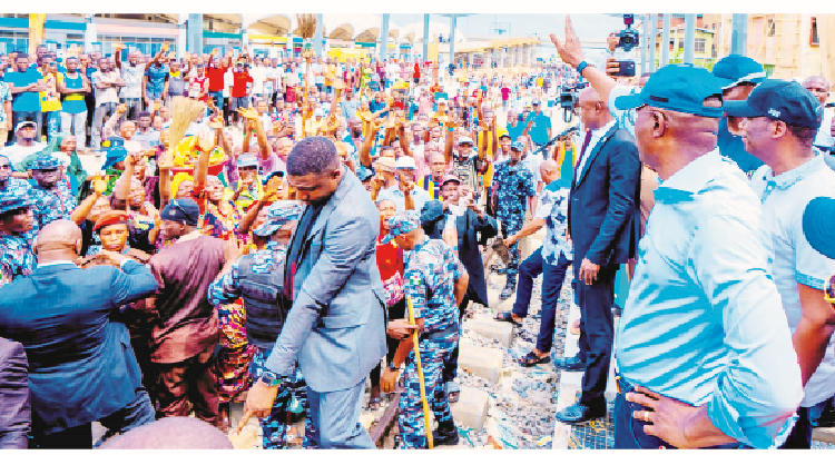 Lagos State Governor Babajide Sanwo-Olu (right) acknowledging greetings from traders during an inspection of the Red Line Rail at Yaba Terminal, with him is the deputy governor, Dr Obafemi Hamzat (second right),in Lagos. PHOTO BY KOLAWOLE ALIU