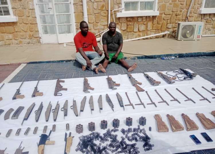 Michael Dung and Yusuf Pam and their large cache of illegal manufactured arms being paraded at the headquarters of OPSH in Jos
