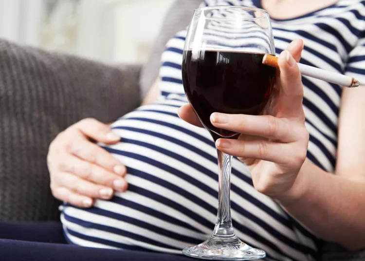 Close Up Of Pregnant Woman Smoking And Drinking