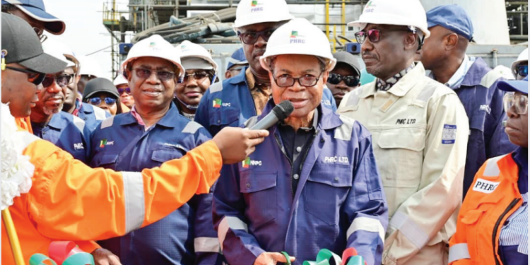 PROMISE KEPT: Chairman, NNPC Board, Chief Pius Akinyelure, cuts a tape to mark the official announcement of the mechanical completion and flare start-up of Area 5 Plant of the Refinery. Standing from right is the GCEO, NNPC Ltd, Mr. Mele Kyari and behind the Board Chairman is the Minister of State for Petroleum Resources (Oil), Senator Heineken Lokpobiri.