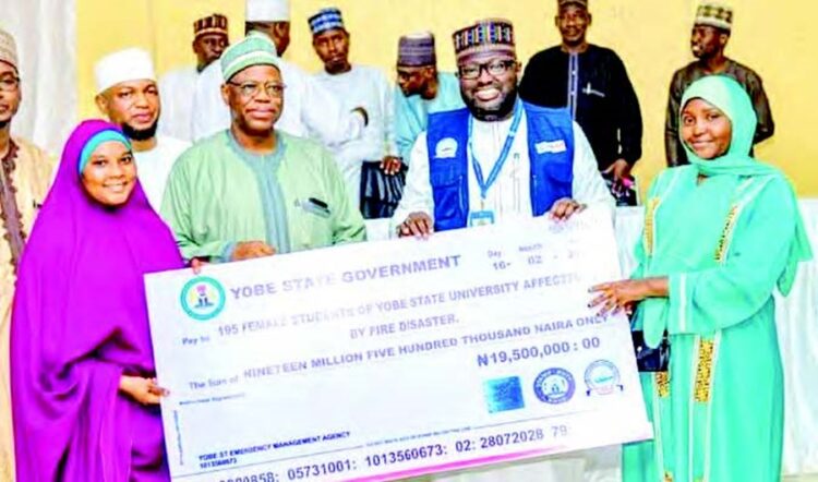 VC Yobe State University, Prof. Mala Daura (2nd left) and the SEMA State director, Rescue, Dr Baba Jalo presenting cash support
to the inferno victims