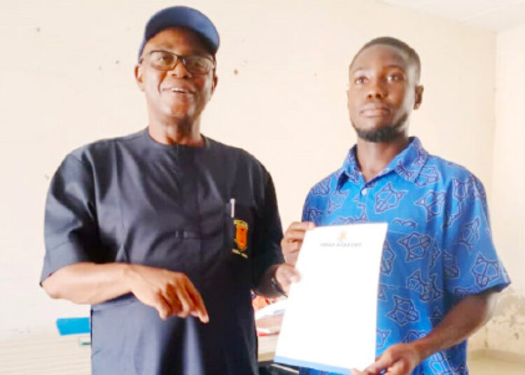 L-R: Proprietor, FOSLA Academy, Sani Abdullahi Lulu presenting employment letter to ex-student of the Institution, Dauda Jibrin as new store manager