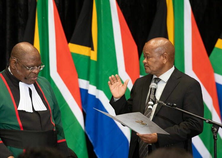 South African Chief Justice Raymond Zondo (L) swears in Senzo Mnchunu, as Minister of Police, in a sitting of the South African Parliament on July 03, 2024, in Cape Town. (Photo by RODGER BOSCH / AFP)