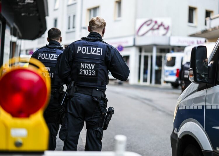 Police officers stand at a cordon in the city center in the early morning in Solingen, Germany, Saturday, Aug. 24, 2024, following Friday's deadly attack at the city's 650th anniversary celebrations. (Christoph Reichwein/dpa via AP)