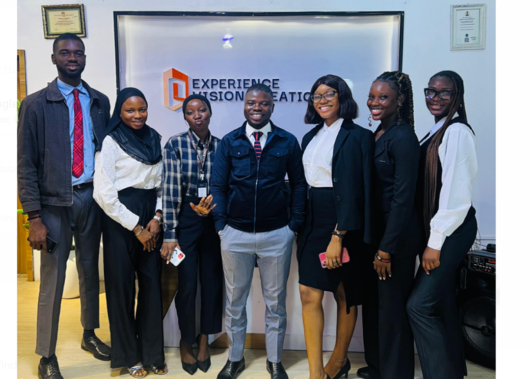 (M) CEO, Experience Vision Creations, Fola Oyedeji flanked on both sides by staff members of the firm during the two-year anniversary celebration.