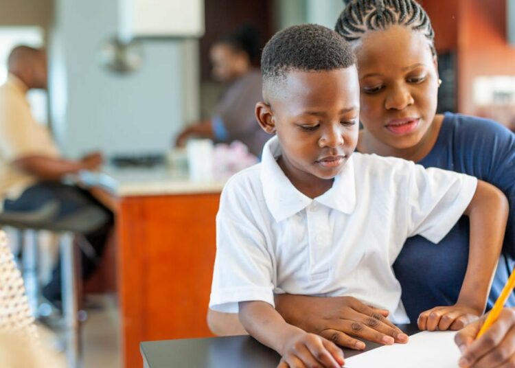 Mother Helping Her Son Do Homework at the Dining Room Table