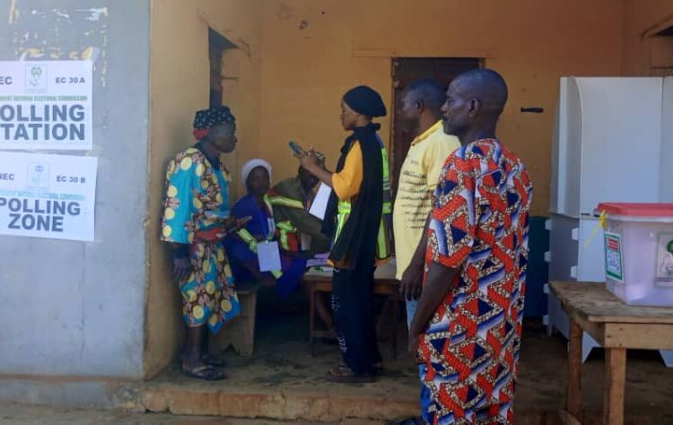 An elderly woman being authenticated for voting