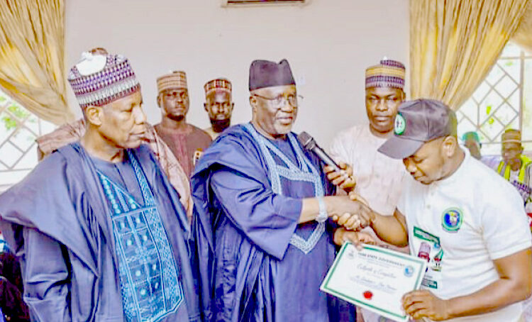 L-R: Yobe State Commissioner for Wealth Creation, Hon Aji Yerima Bularafa, and the Deputy Governor, Hon Idi Barde Gubana presenting a certificate to a shoemaking trainee in Damaturu.