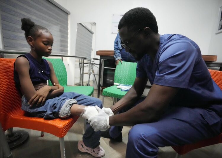 A prosthetist molds a cast for Princess Igbinosa, 10, who lost her leg following a traffic accident in Lagos, Nigeria, Thursday, Nov. 30, 2023. Princess can now walk, thanks to an artificial limb from the IREDE Foundation, a group providing children like her with free prosthetics and helping their families offset the average cost of $2,000 to $3,000. (AP Photo/Sunday Alamba)