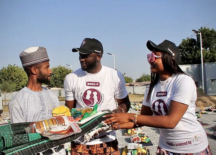 FIRS Staff, Akpana Benedicta and Actor and film maker, Dr. Uzee Usman presenting items to one of the beneficiaries