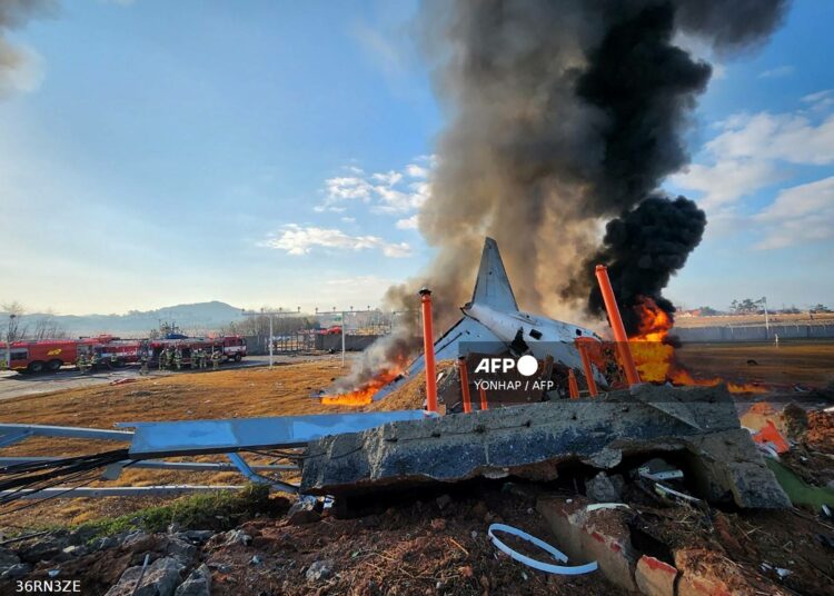 fire and smoke rise from the tail section of a Jeju Air Boeing 737-800 series aircraft after the plane crashed and burst into flames at Muan International Airport in South Jeolla Province, some 288 kilometres southwest of Seoul on December 29, 2024. - A Jeju Air plane carrying 181 people from Bangkok to South Korea crashed on arrival on December 29, authorities told AFP, with 29 confirmed dead and dramatic video showing the aircraft bursting into flames. (Photo by YONHAP / AFP) / - South Korea OUT / NO USE AFTER JANUARY 8, 2025 02:48:46 GMT -  - SOUTH KOREA OUT / NO ARCHIVES -  RESTRICTED TO SUBSCRIPTION USE