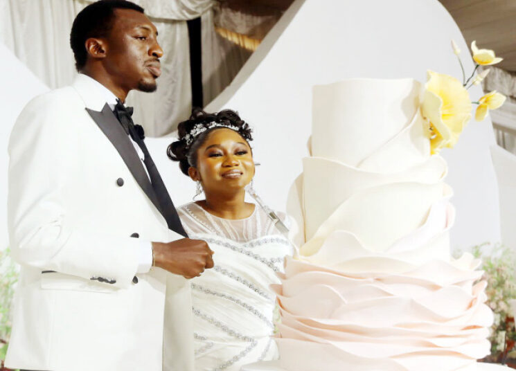 The newly married, Iyanuoluwa and Adedayo, and their wedding cake during the reception