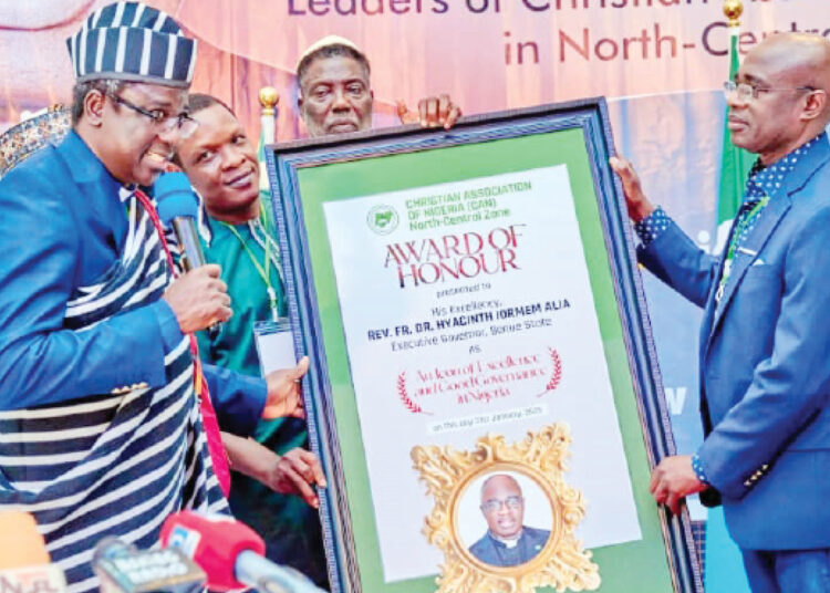 Rev. Dr. Samson Jonah presenting award to Governor Hyacinth Alia