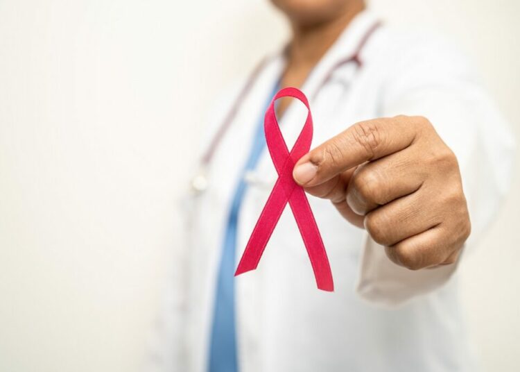 Breast cancer, Asian doctor woman with pink ribbon, symbol of World Breast Cancer Day.