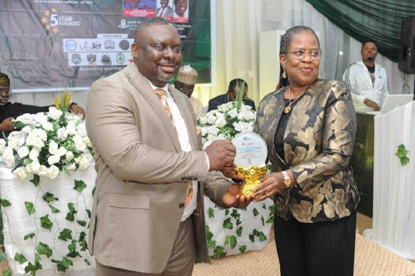 Benue FA Boss Advocates Women’s Football Teams At Newstap/SWAN Awards 1 Dr. Edeh receiving his award from Mrs. Abubakar