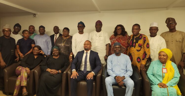The Director-General of SMEDAN, Charles Odii, (3rd from right on front row), members of his management team and journalists during an interactive session in Abuja.