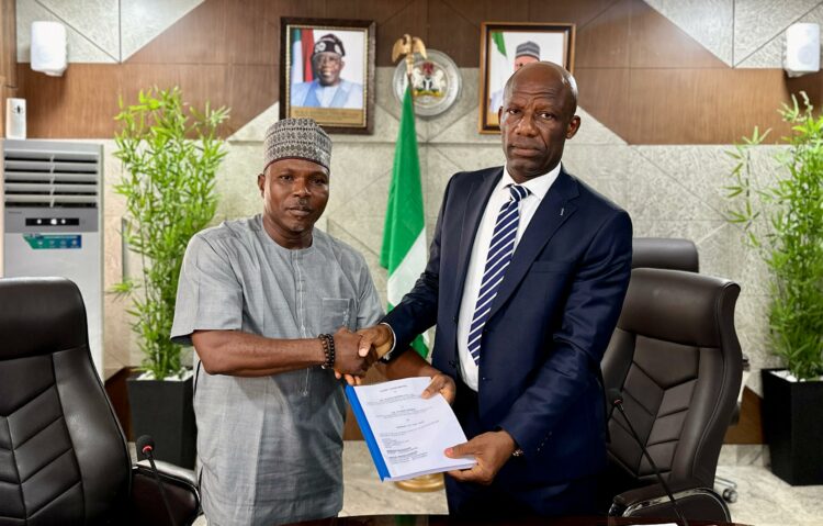Mr Ogbodo Chinasa Nnam, Permanent Secretary, Federal Ministry of Information and National Orientation (left) receiving hand over documents from Mr Ibidapo Okunnu (right) who oversaw the office, on Monday May 12 2025