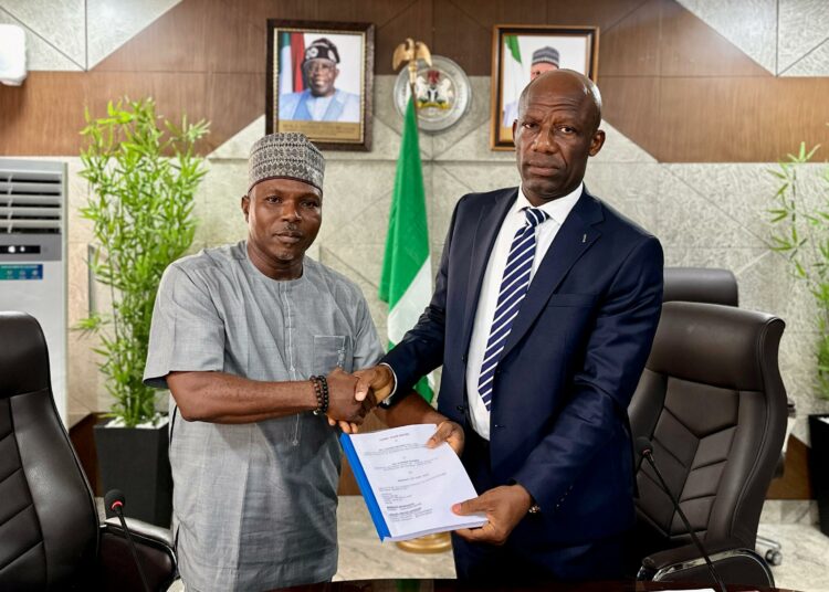 Mr Ogbodo Chinasa Nnam, Permanent Secretary, Federal Ministry of Information and National Orientation (left) receiving hand over documents from Mr Ibidapo Okunnu (right) who oversaw the office, on Monday May 12 2025