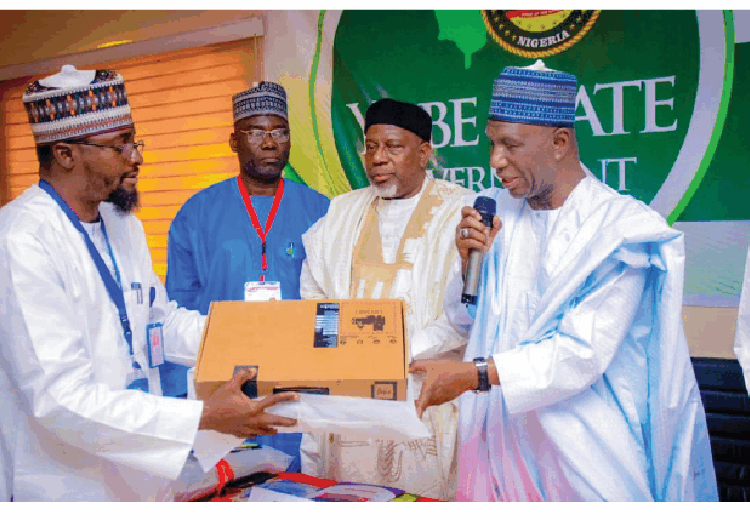 Yobe SSG, Alhaji Baba Mal. Wali (right) while presenting a laptop to a focal person during a capacity building training organised by his office in Kano.