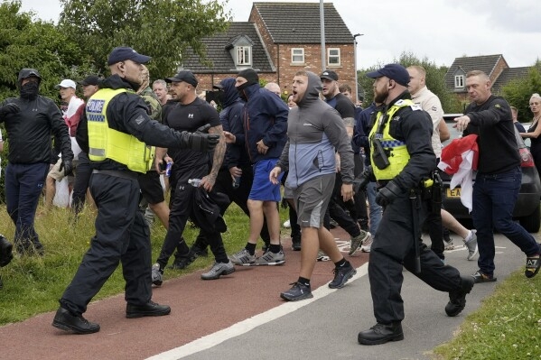 Activists Clash With Police, Anti-Migrant Protesters In UK 1 download 4