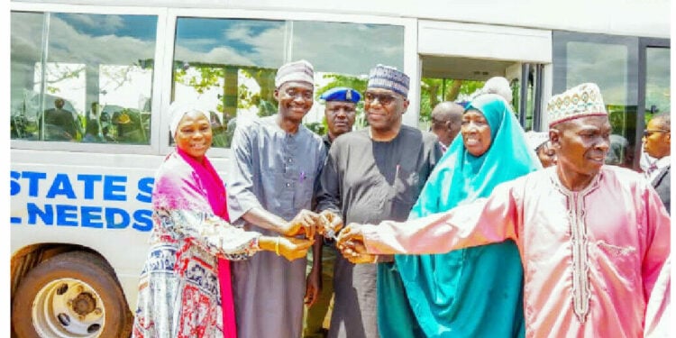 Kwara State governor, AbdulRahman AbdulRazaq presenting the key of a coaster bus to the principal of the School For Special Needs, Ilorin, Alh AbdulGaniyi Olododo on Tuesday.