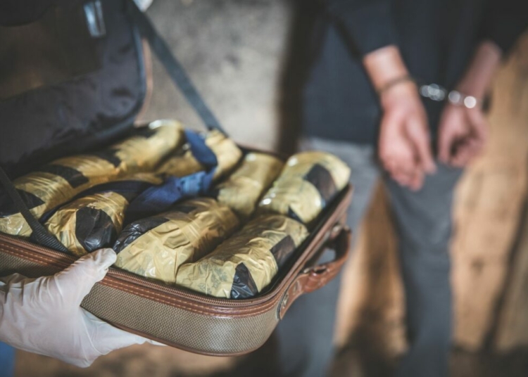 Drug Trafficking: Court Jails Clearing Agent, Orders Forfeiture Of 3 Vehicles 1 Police arrest drug trafficker with handcuffs. Law and police concept. World Anti-drug Day