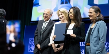 China Makes History As 2 Nationals Win Mathematics’ Top Fields Medal 3 Mathematician Wang Hong, center right, poses for photos after being awarded the 2026 Fields Medal on July 23. Erin Blewett/AFP/Getty Images