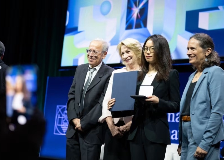 Mathematician Wang Hong, center right, poses for photos after being awarded the 2026 Fields Medal on July 23. Erin Blewett/AFP/Getty Images