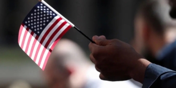 A citizenship candidate holds a flag during the U.S. Citizenship and Immigration Services (USCIS) naturalization ceremony at Rockefeller Plaza in New York City, U.S., September 17, 2019. REUTERS/Shannon Stapleton