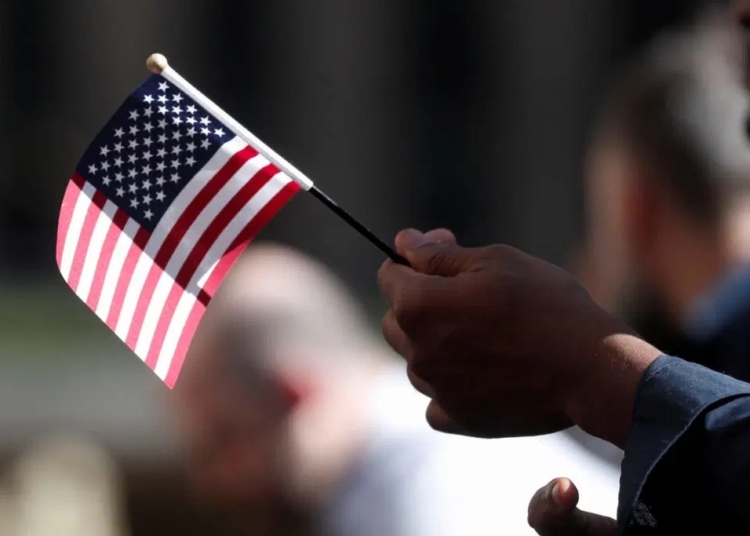 US Explains What Determines How Long Foreign Visitors Can Remain In The Country 1 A citizenship candidate holds a flag during the U.S. Citizenship and Immigration Services (USCIS) naturalization ceremony at Rockefeller Plaza in New York City, U.S., September 17, 2019. REUTERS/Shannon Stapleton