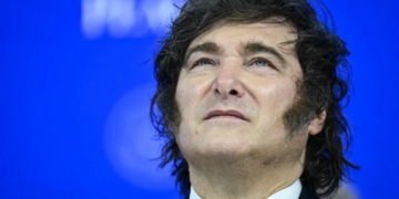 Argentina’s President Javier Milei looks on as he attends the “Board of Peace” meeting during the World Economic Forum (WEF) annual meeting in Davos on January 22, 2026. Argentine President Javier Milei has amended the Immigration Act by decree to ban the entry of foreign nationals who express hate speech against the South American country, according to the text published on July 29, 2026 evening, which is to be submitted to Congress. (Photo by Mandel NGAN / AFP)