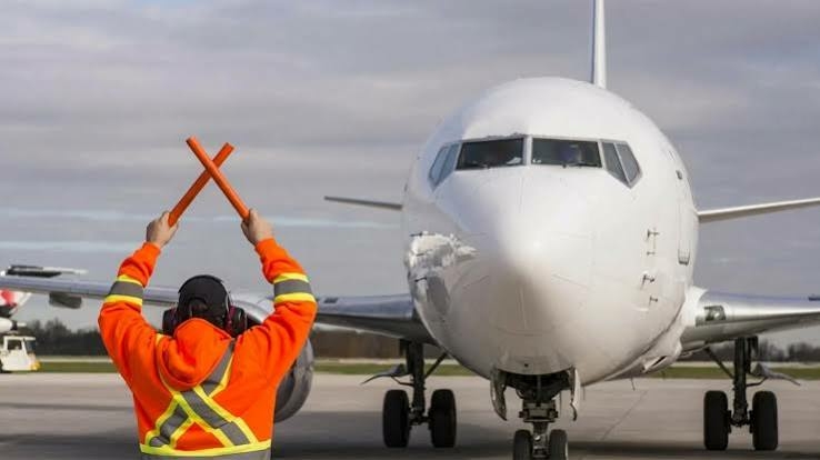 Safety Concerns Grow As NCAA Halts Critical Training For Aviation Workers 1 An Air Transport Worker signalling to a plane.