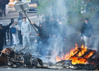 A protestor throws a stop sign into a fire as protesting students carry out blockading action near the Kerichen high school in Brest, western France, on October 2, 2026