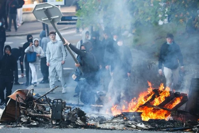 A protestor throws a stop sign into a fire as protesting students carry out blockading action near the Kerichen high school in Brest, western France, on October 2, 2026