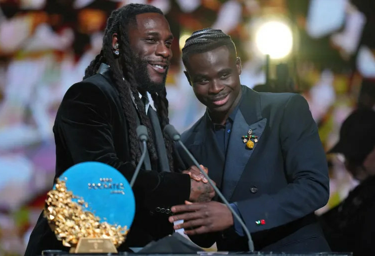 Ballon D’Or: Saka Wins Socrates Award For Community Impact 1 Saka receives the Socrates Award, recognising social action and humanitarian work, from singer Burna Boy. AP Photo